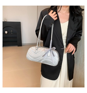 Silver bow shoulder bag with water ripple texture worn with a black blazer