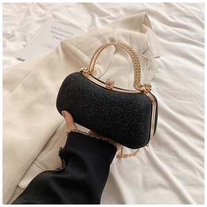 Detail of black glitter evening clutch with crystal gold handle and metallic chain strap