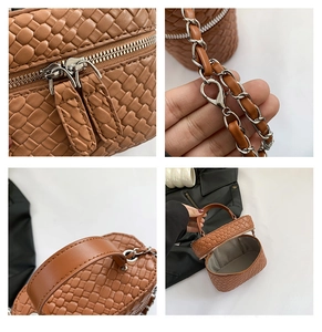 Dettaglio della mini borsa a secchiello marrone intrecciata con doppia zip e tracolla a catena