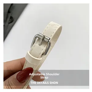 Close-up of adjustable cream leather strap with silver metal buckle on bucket bag