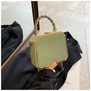 Green octagonal box bag featuring golden metal frame and spiral top handle detail