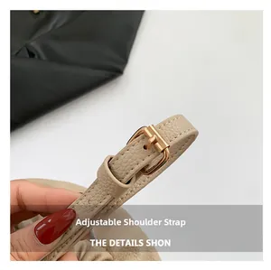 Close-up of beige lychee grain leather adjustable strap with gold-tone buckle