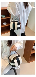 Detail einer schwarz-weiß gestreiften Mini-Eimertasche mit Ledergriff und Kettenriemen