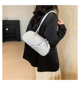 Close-up of pearl silver bow shoulder bag featuring wave texture and blue mesh bow