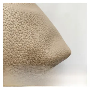 Detailed close-up of premium beige lychee pattern faux leather texture on bucket bag