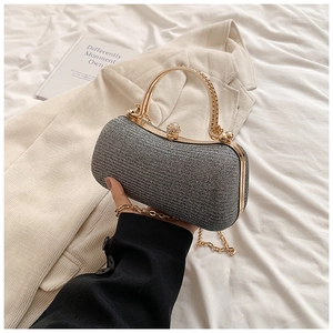 Detail of silver glitter evening clutch with gold metal handle and pearl clasp detail