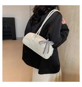 Close-up of stylish bow tie accent on marble pattern handbag with a shoulder strap