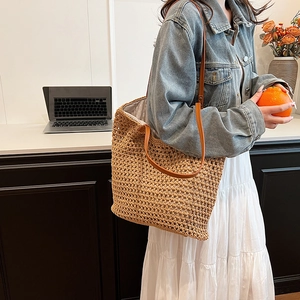 Handmade woven tote bag with brown leather straps and large straw hollow texture