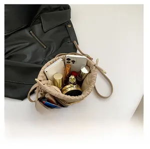 Top view of beige drawstring bucket bag showing spacious interior with cosmetics