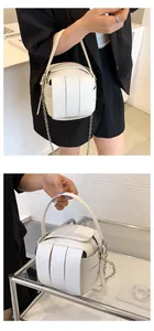 Detailansicht der weißen geflochtenen Eimertasche mit Kreuzmuster und Metallkette