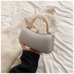 Detailed view of sparkling silver evening bag with golden clasp and round metal handle