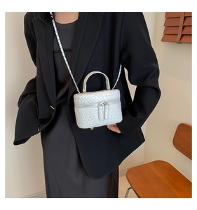 Dettaglio mini borsa intrecciata bianca con tracolla a catena e doppia zip