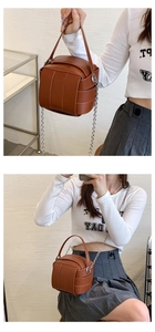 Detailansicht der braunen Leder-Beuteltasche mit Flechtmuster, Kette und Umhängegurt