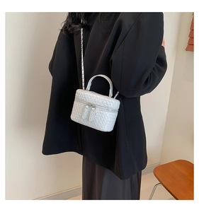 Dettaglio mini borsa a scatola bianca intrecciata con tracolla a catena e zip in metallo