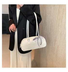 Detail of cream white bow handbag with ripple texture and plaid silk scarf decoration