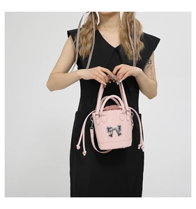 Detail of pink bucket bag with silver bow ornament and drawstring closure