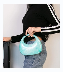 Detailed close-up of mint green marble acrylic handbag with crescent moon design