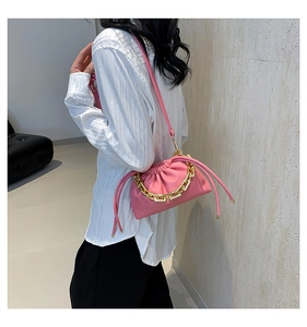 Fashionable pink ruched cloud bag shown on model with chunky gold chain and slim strap