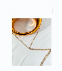 Detailed close-up of premium golden circular metal handle and elegant chain on moon bag