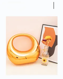 Artistic gold crescent moon acrylic bag displayed with flowers in a soft lighting setting