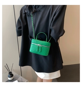 Dettaglio mini borsa a secchiello verde con stampa coccodrillo e tracolla a catena