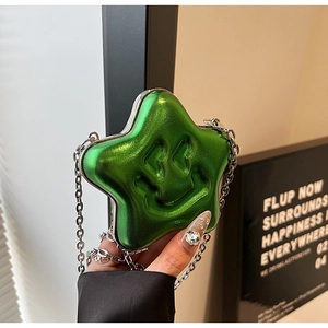 Detail of green star-shaped crossbody bag featuring a 3D smiley face and silver chain