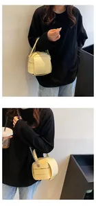 Detail der beigen gewebten Leder-Beuteltasche mit grober Gitterstruktur und Kette