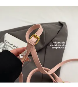 Detail of pink leather shoulder strap with adjustable golden buckle and stitching