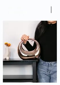 Close-up of a model holding the rose gold circular hollow sculptural acrylic vase