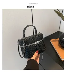 Dettaglio della trama intrecciata nera e delle doppie cerniere della mini borsa a secchiello
