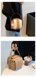 Makro-Detail der gewebten Würfeltasche mit Patchwork-Textur und silberner Metallkette