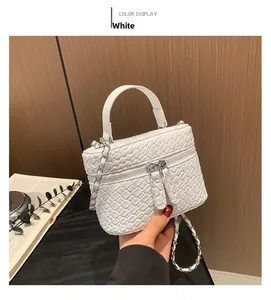 Dettaglio della mini borsa a secchiello bianca intrecciata con catena e doppia cerniera