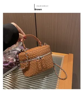 Dettaglio mini borsa a secchiello marrone intrecciata con cerniera dorata