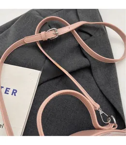 Détail de la bandoulière réglable en cuir rose pâle avec fermoirs mousquetons argentés
