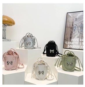 Detail view of five colors mini bucket bags with bow accessory and drawstring closure