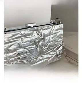 Detail shot of silver metallic pleated clutch bag with fine chain strap and clasp