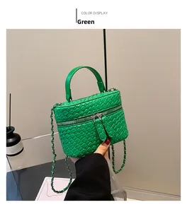 Dettaglio della mini borsa vanity verde intrecciata con tracolla a catena a mano
