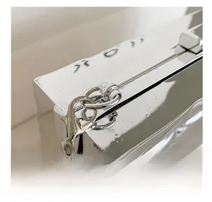 Detail shot of the silver metallic clasp and fine chain on a diamond pattern party bag