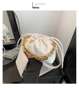 Detail of white lychee leather drawstring bag with a chunky gold metal chain handle