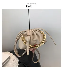 Detail of khaki pleated cloud bag featuring chunky gold chain and lychee leather texture