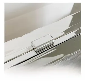 Macro detail of the silver metallic clasp on a quilted evening bag showing glossy finish