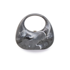 Acrylic crescent clutch with grey marble pattern and circular handle for evening wear
