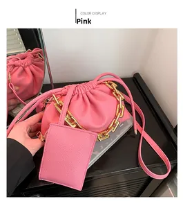 Detailed shot of pink pleated cloud bag with chunky gold chain and small coin pouch