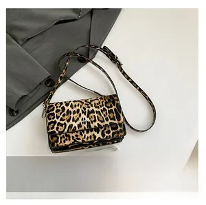 Macro view of leopard print texture and metal buckle on the stylish underarm bag