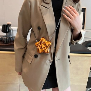 Star-shaped orange crossbody bag with embossed smiley face and silver chain strap
