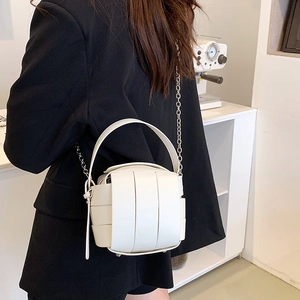 Weiße geflochtene Eimertasche mit Kettenriemen am Modell in modernem professionellem Stil