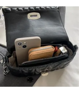 Interior view of black quilted crossbody bag showing storage for phone and wallet