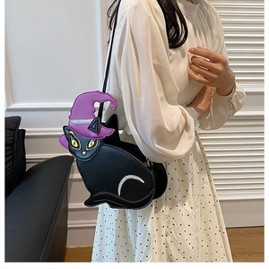 Close-up of cat-shaped crossbody bag with wizard hat and moon detail on a model