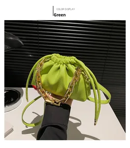 Detail of green ruched cloud bag with bold gold chain link strap and lychee grain leather