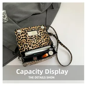 Close-up of leopard print shoulder bag interior with built-in mirror and daily essentials